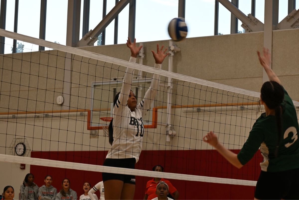 Volleyball player at a bhcc game serving the ball