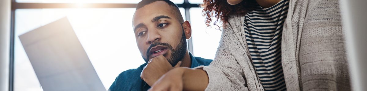 2 people looking at a document Two employees looking over a paper form.