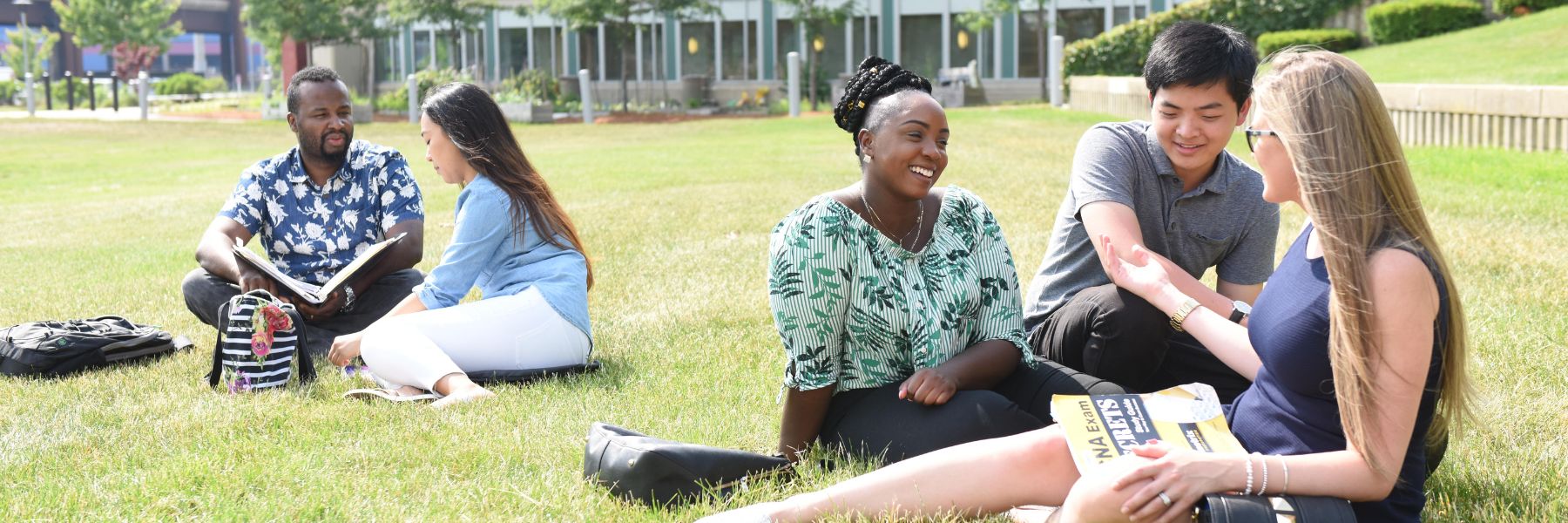 students sitting together on the BHCC lawn 