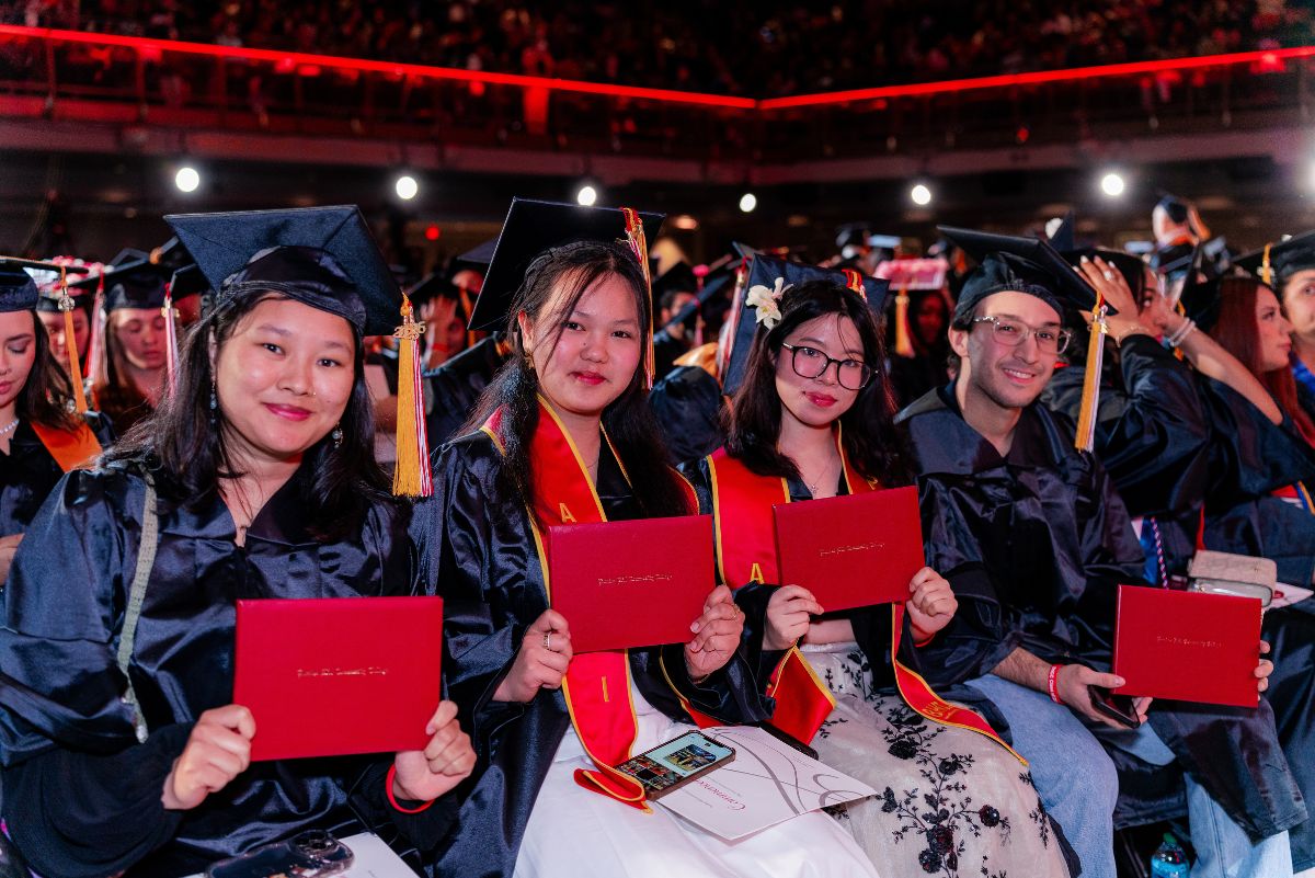 Students at commencement with diploma