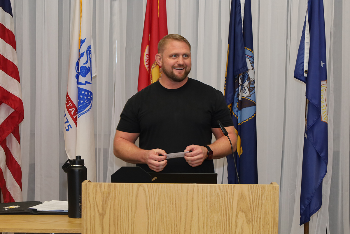 speaker at a podium with flags