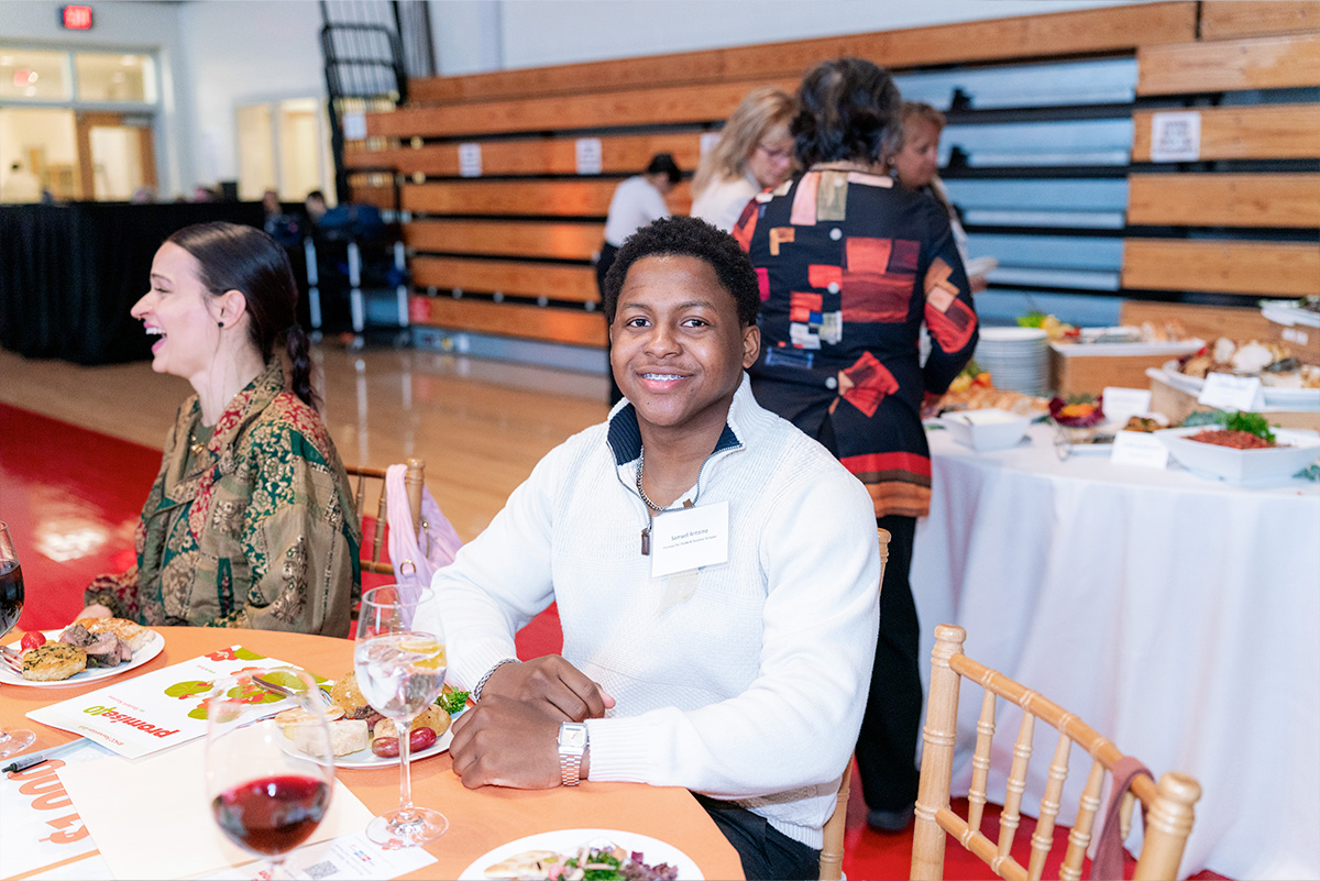 student at a dinner table at a gala