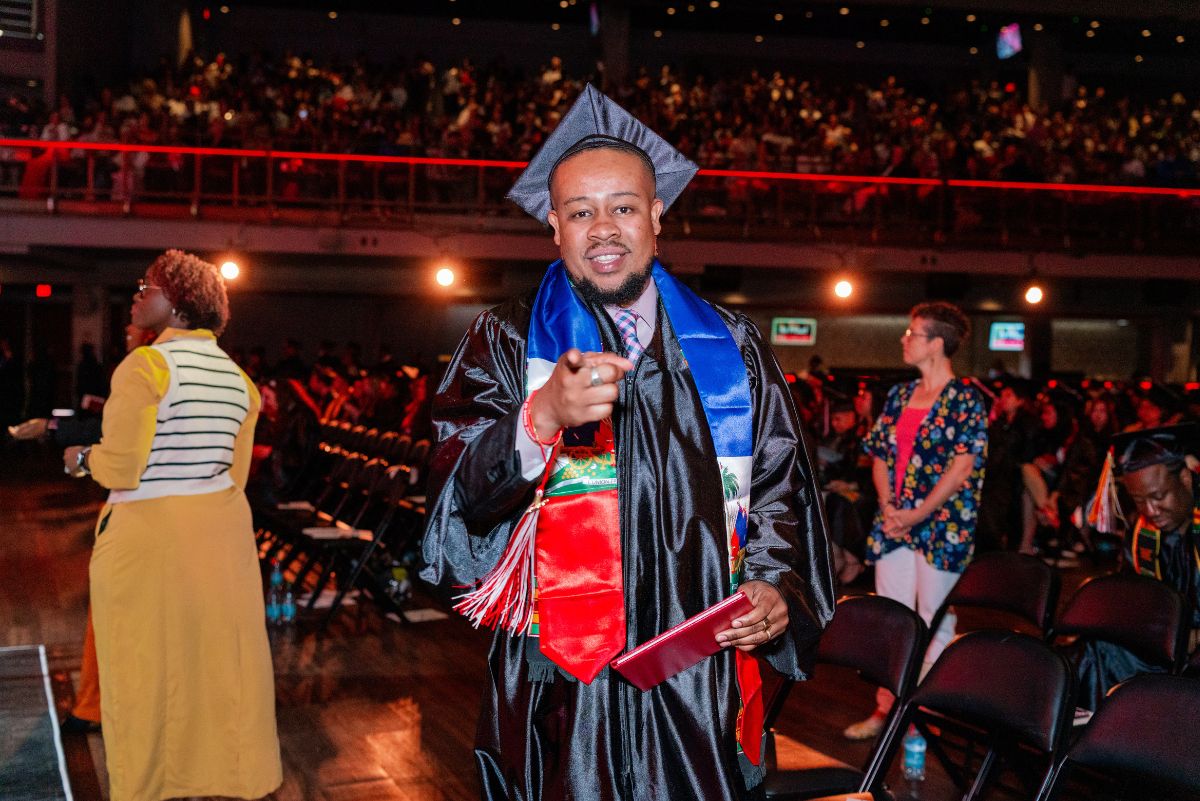 student pointing at commencement