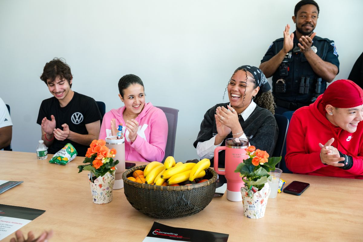 Students around table clapping and laughing