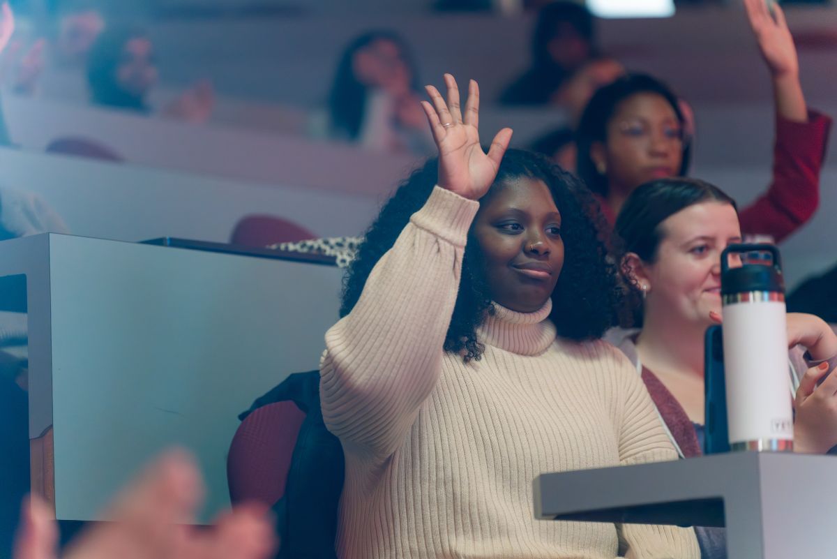 Student raising hand at event