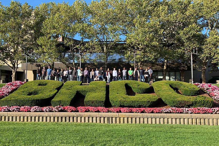 Students and mentors in front on the BHCC shrubs