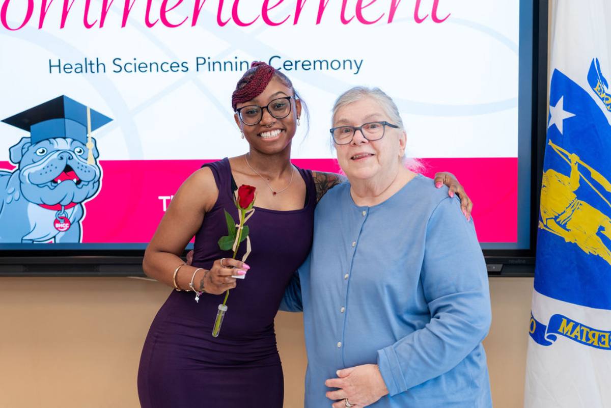 student with a flower getting her pin