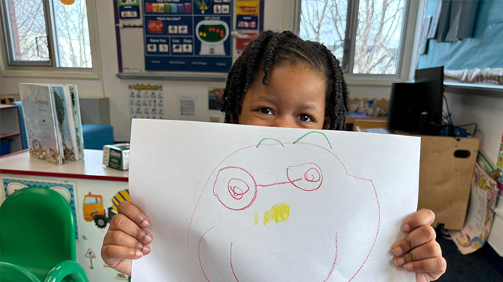 child holding a drawing